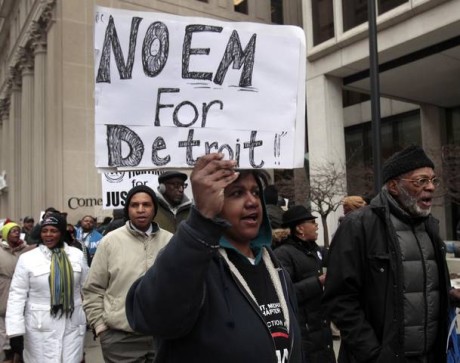 Group of protesters demonstrate against Michigan Governor Snyder's appointment of emergency financial manager for city of Detroit during rally outside federal building in downtown Detroit, Michigan